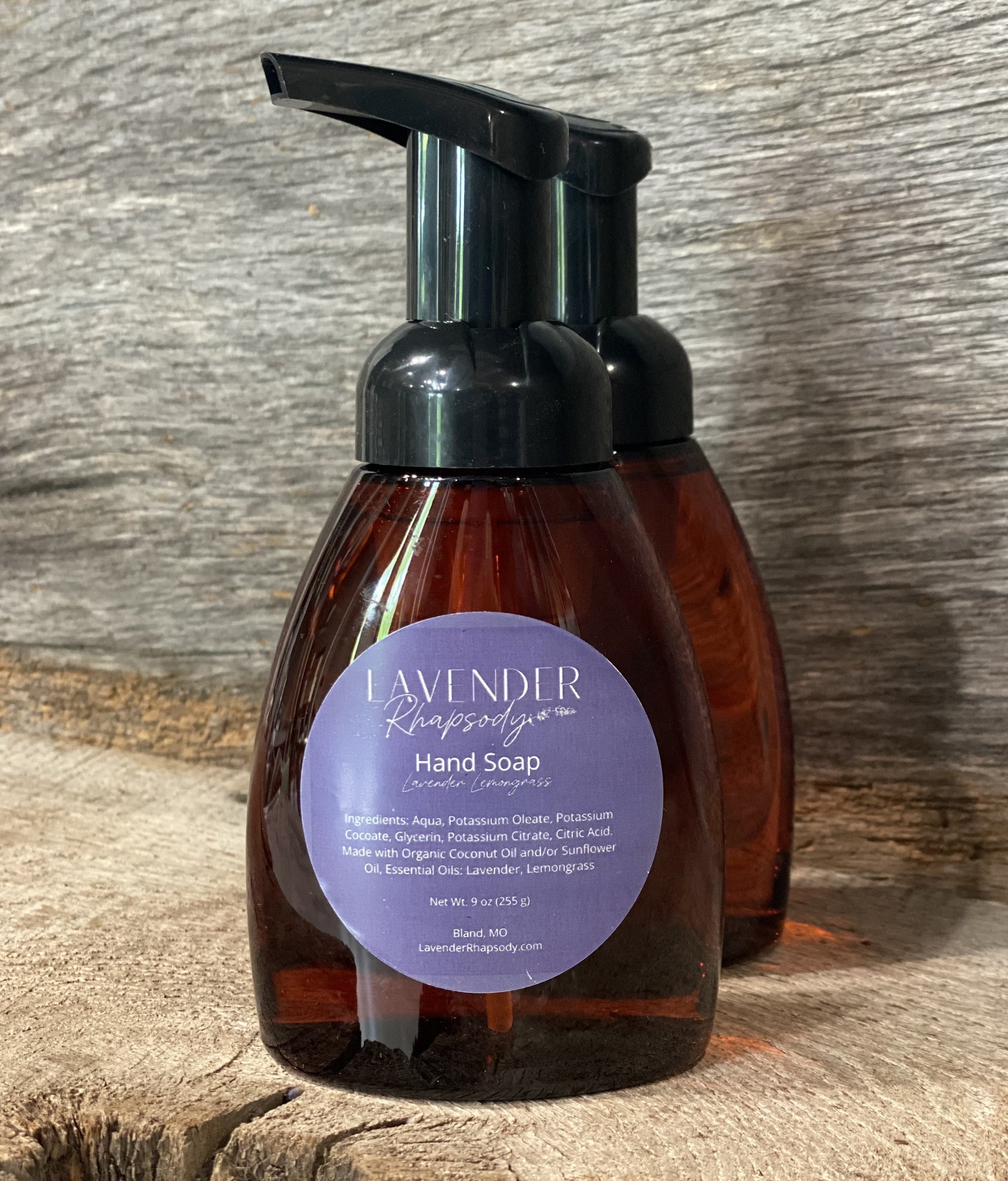 Two bottles of Lavender Hand Soap on a wooden surface
